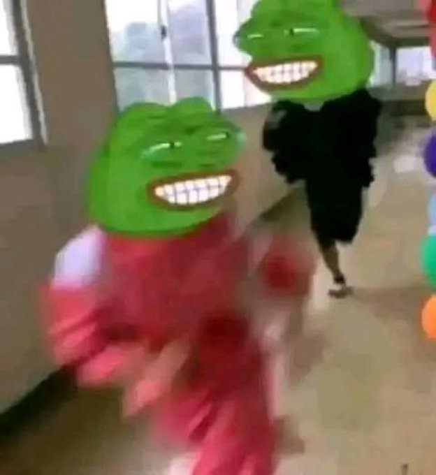 A blurry video screenshot of two people dancing energetically in what appears to be a school hallway, with their faces edited to show the smiling green Pepe the Frog meme character.