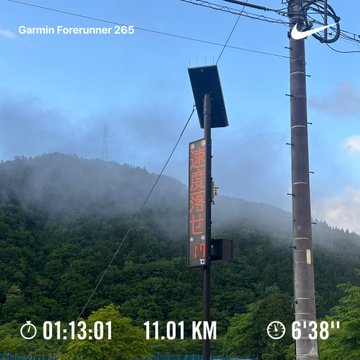 The image shows a street sign with the time of 11:01, along with an elevation reading of 638 meters above sea level. The sign also displays the distance as 100x3.01 km. This information suggests that the photo was taken during a run or hike in a mountainous area where the runner has reached a certain point and is now heading towards their destination.