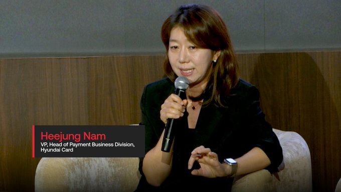 Speaker presentation photo showing 'Heejung Nam, VP, Head of Payment Business Division, Hyundai Card' speaking into a microphone.