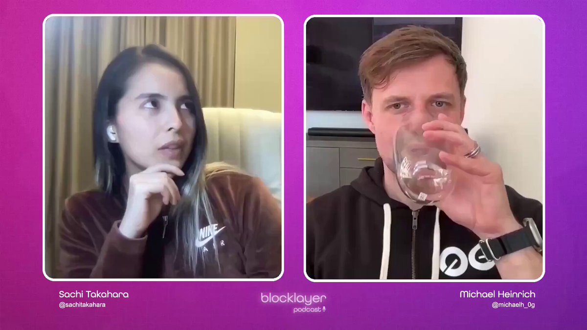 The image shows a conversation between two people sitting next to each other at a table with wine glasses placed on top. The woman has her hand resting on her chin while the man holds his glass of water, possibly contemplating something or waiting for someone. They are both wearing brown clothing and appear to be engaged in an interesting discussion.