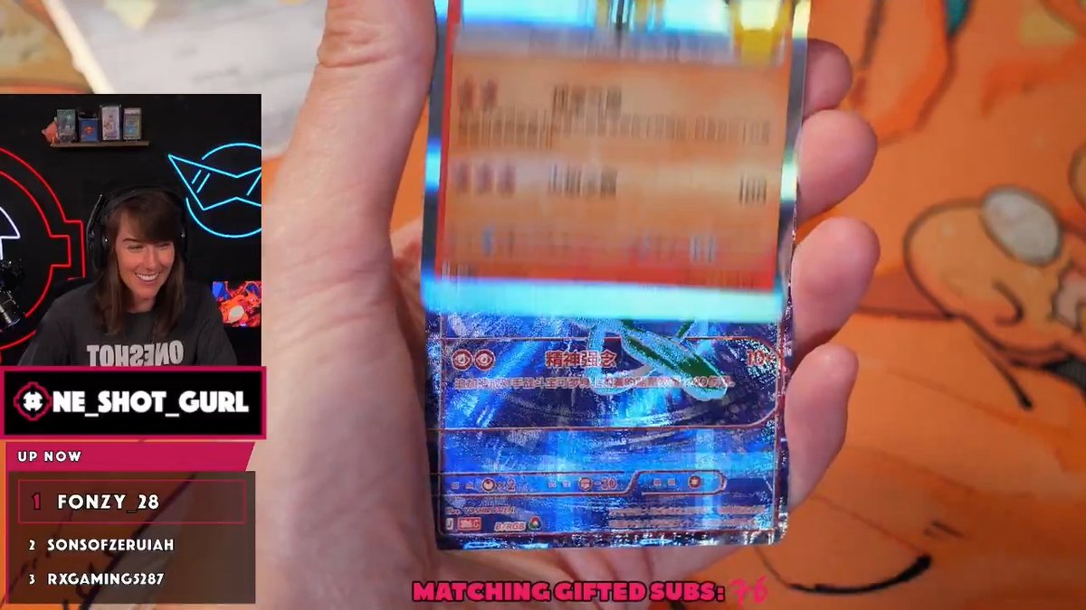 A Twitch stream screenshot showing a streamer named 'ONE_SHOT_GURL' in a webcam box, holding up a Pokémon trading card, with overlay text 'MATCHING GIFTED SUBS' and a list of recent subscribers.