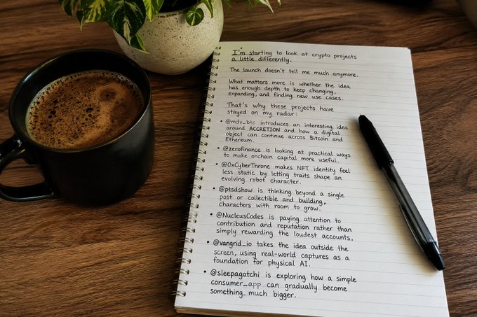 A handwritten notebook on a wooden desk lists crypto projects and their potential evolution beyond initial concepts, accompanied by a black coffee mug and pen, reflecting the thoughtful exploration of whether crypto projects can grow beyond their first impression into something more meaningful.