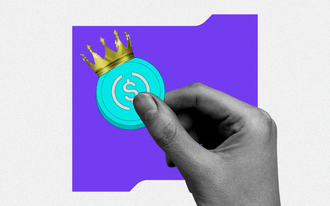 A collage-style image showing a hand pinching a teal USDC stablecoin coin topped with a gold crown, set against a purple folder/folder-tab background.