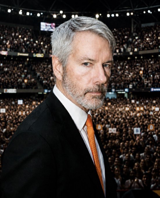 Michael Saylor, founder and executive chairman of MicroStrategy ($MSTR), stands confidently in a suit and orange tie against the backdrop of a packed arena, symbolizing the company's transformation from its low point in 2002 to its massive shareholder base today.