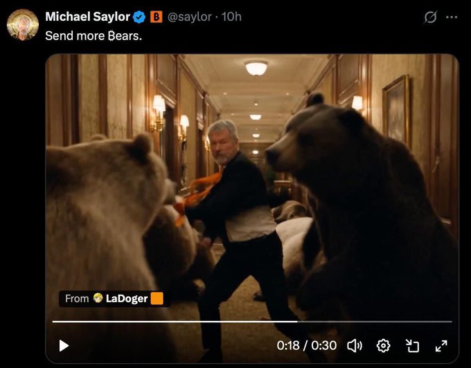 A tweet from Michael Saylor (@saylor) saying "Send more Bears." accompanied by a video of a man fighting bears in a hallway, posted by LaDoger. The video, which appears to be a parody of a popular Coca-Cola commercial, humorously aligns with the accompanying post about Saylor taunting bearish market critics.