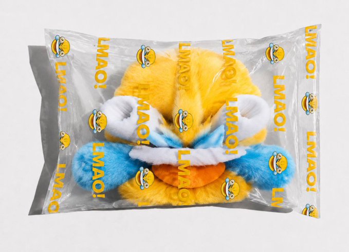 A plush toy featuring blue, yellow, and orange fur with a mischievous grin is packaged in a clear plastic bag printed with repeating "LMAO!" text and cartoon smiley emojis, visually capturing the playful "bags are packed" energy of the post.