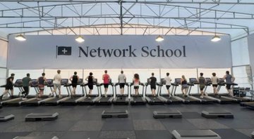 A row of treadmills is displayed beneath a large banner reading "Network School" inside a glass-ceilinged facility. The image appears to illustrate Balaji Srinivasan's Network School project, referencing his prominence as a crypto investor and former Coinbase CTO whose early backing often draws significant attention to primary market cryptocurrency investments.