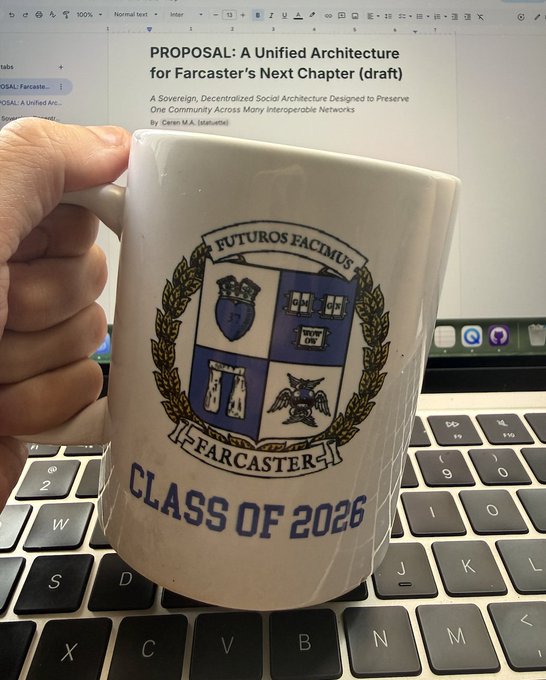 Hand holding a white coffee mug with a Farcaster 'Class of 2026' crest, in front of a laptop displaying a proposal titled 'A Unified Architecture for Farcaster's Next Chapter.'