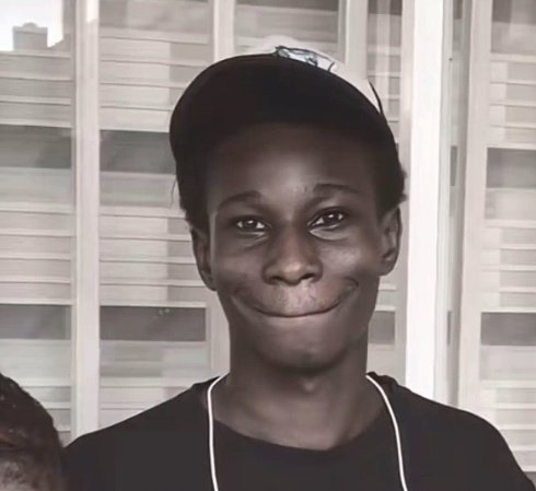 The image shows a young person wearing a backwards baseball cap and earphones, smiling wryly at the camera against a backdrop of window shutters. Their slightly self-deprecating, knowing expression pairs well with the caption's message about an unsuccessful experience with "Degen" using half of an X (formerly Twitter) payout, suggesting a relatable look of someone admitting a financial misstep.