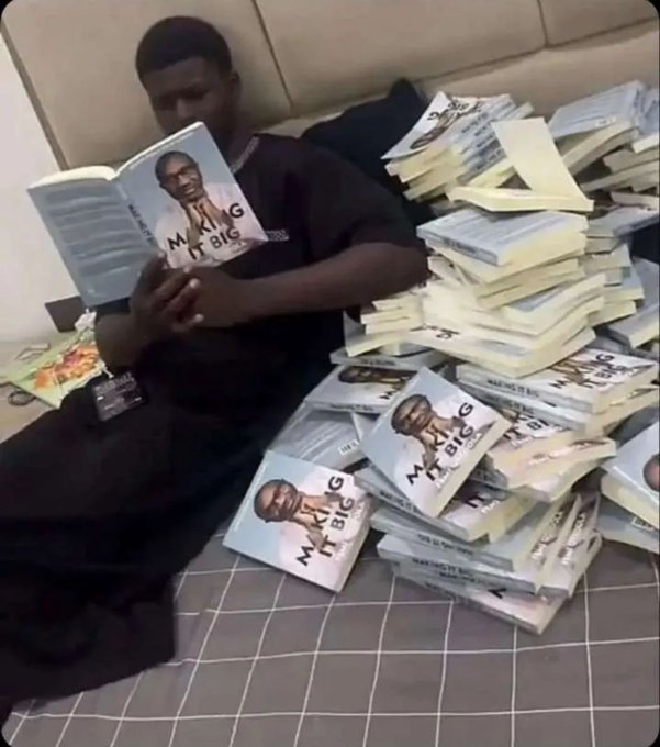A young man sits cross-legged on a checkered blanket reading a book titled "MAKING IT BIG," surrounded by massive stacks of the same book, humorously suggesting the key to his success in crypto trading lies within its pages—fittingly captioned with a cheerful "gm ct we go again today!" for the crypto Twitter community.