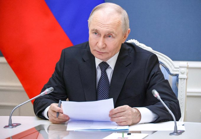 Russian President Vladimir Putin signs a law establishing Russia's legal framework for cryptocurrencies and digital assets, as seen in this image of him reviewing documents.