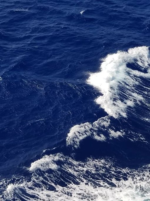 Waves crash against each other in a deep blue ocean, viewed from above. The chaotic movement of the water mirrors the volatile and unpredictable nature of cryptocurrency markets, echoing the post's confident claim that the "XRP Supercycle is just getting started."