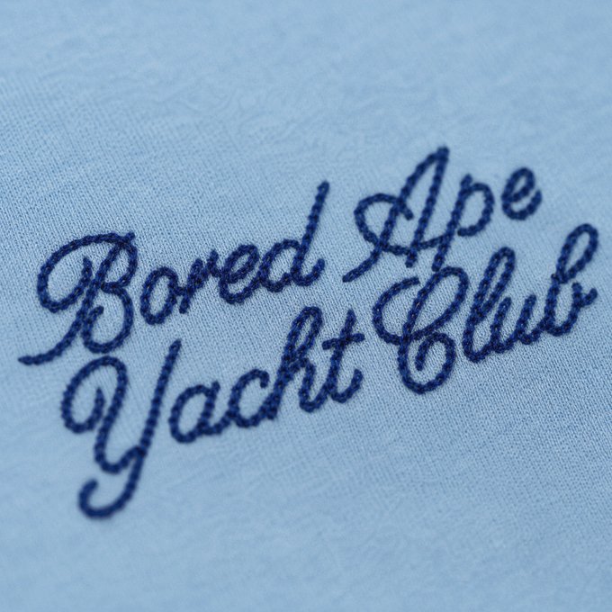 Embroidered navy blue cursive text on light blue fabric reading 'Bored Ape Yacht Club'.