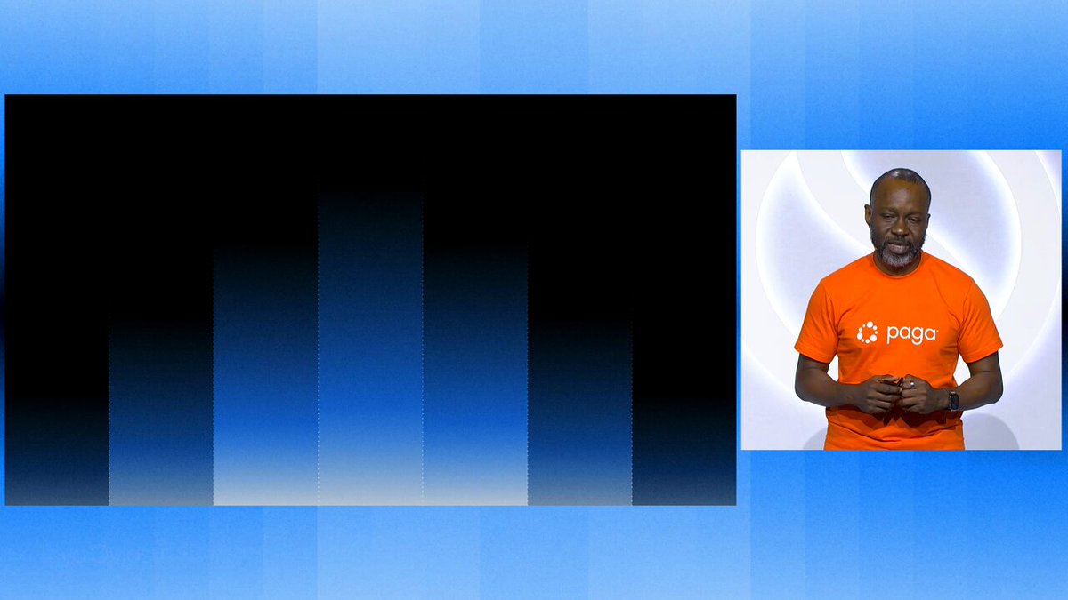 A man wearing an orange shirt stands on stage next to a large screen displaying an advertisement related to Paga. The advertisement shows that Paga processed $11B in payments and transactions across Africa, highlighting its global reach and impact. The scale of transactions and the money involved are clearly depicted through the financial details provided by the image.