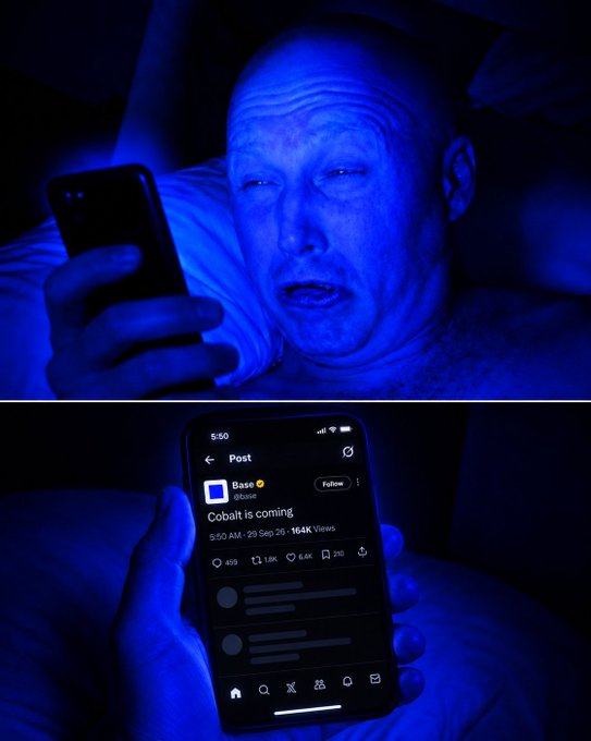 A person in bed, bathed in blue light, looks wide-eyed at their phone displaying a post from Base (@base) reading "Cobalt is coming" with 164K views at 5:50 AM on 29 Sep 26—capturing the moment of waking up excited and bullish on Base.