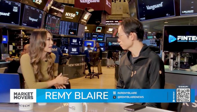 On the set of FINTECH TV's "Market Movers" program at the New York Stock Exchange, host Remy Blaire interviews a male guest in a black jacket. The interview appears in conjunction with a discussion about AI agents and their future impact, featuring Yat Siu as the featured guest on the broadcast.