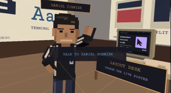 A scene from a voxel-style video game showing a blocky character named 'DANIEL SCHMIER' with an interaction prompt 'TALK TO DANIEL SCHMIER' and a 'LAYOUT DESK' sign reading 'CHANGE THE LIVE POSTER'.