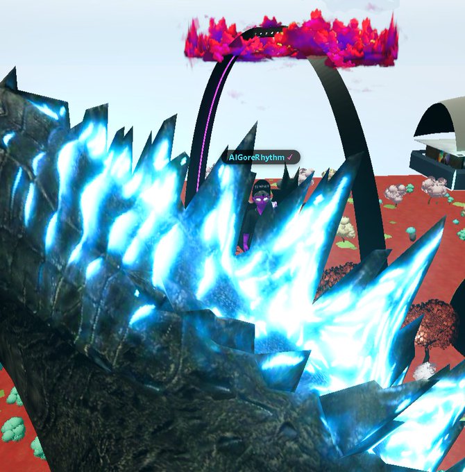 A 3D virtual environment scene featuring a character with the username 'AIGORERHYTHM' standing beneath a large pink and red fiery archway, with jagged blue glowing crystal spikes in the foreground.