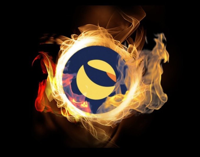 A stylized digital logo featuring a stylized 'e' or eye shape rendered in yellow and dark blue, engulfed in dynamic orange and white flames against a black background.