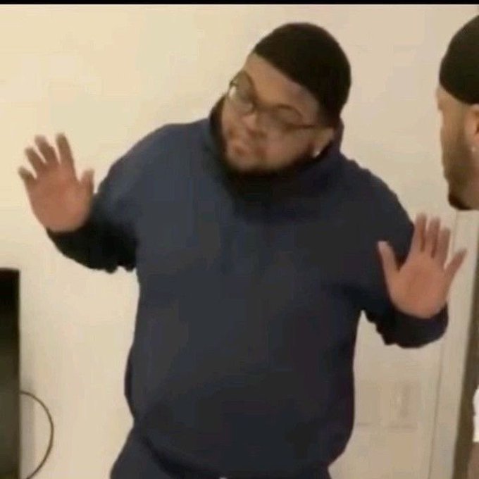 A man in a dark hoodie and beanie holds his hands up in a dismissive "what can you do?" gesture, visually echoing the post's resigned tone about the Packers' defensive struggles against both Jordan Love and the run game.