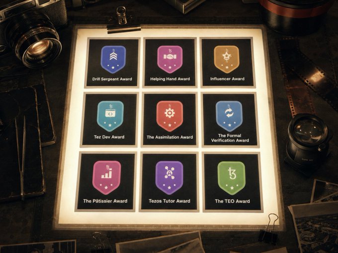 A collection of nine achievement badges including 'Drill Sergeant Award', 'Helping Hand Award', 'Influencer Award', 'Tez Dev Award', 'The Assimilation Award', 'The Formal Verification Award', 'The Plâtissier Award', 'Tezos Tutor Award', and 'The TEO Award'.