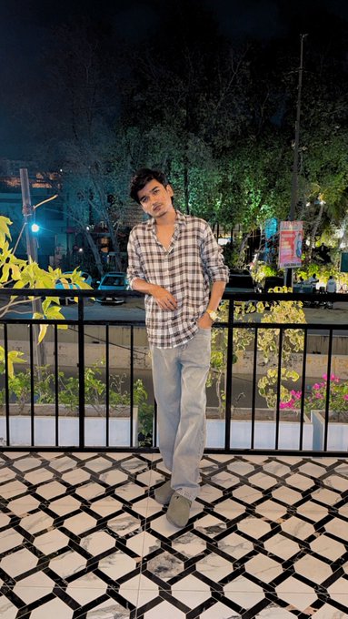 A young man poses confidently on a tiled balcony at night in a checkered shirt and jeans, leaning against a railing with a street and trees in the background.

The image captures a celebratory, triumphant mood that aligns with the post's theme of "celebrating small wins"—the subject's relaxed yet proud pose symbolizes the milestones mentioned, such as joining Labyrth as a creator and earning from web3 content.