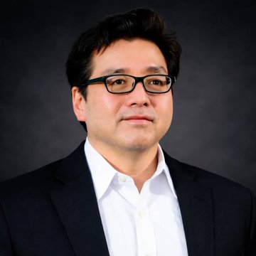 A professional headshot of a man with dark hair, glasses, a black suit jacket, and a white shirt, likely a company executive or board member associated with BitMine's Ethereum treasury holdings announcement. The image accompanies news of BitMine expanding its crypto portfolio to 4.9% of Ethereum's total supply.