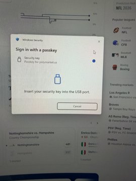 A Windows Security prompt titled "Sign in with a passkey" requests the user to insert a security key for Polymarket.us into a USB port, with a Cancel button below. The user's tweet explains they are stuck on this passkey screen while trying to access Polymarket on their PC and are seeking help bypassing it.