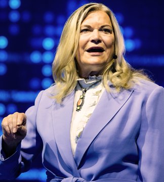 A blonde-haired woman in a lavender blazer speaks passionately at what appears to be a public event with blue stage lighting behind her, likely depicting Senator Cynthia Lummis as referenced in the accompanying post about the upcoming CLARITY Act vote scheduled for September 15.