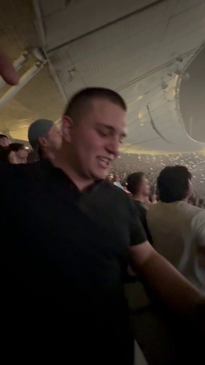 The image depicts a man dressed in black at a concert, with other people visible around him. A caption has been added to the image, which says "Won 2400 $USDT on Ye's concert while listening Heartless $100 Giveaway Below Like, Rt And Tag 3 Friends". The post is related to a giveaway that promises money for those who share and like the image of the man enjoying his time at the concert.