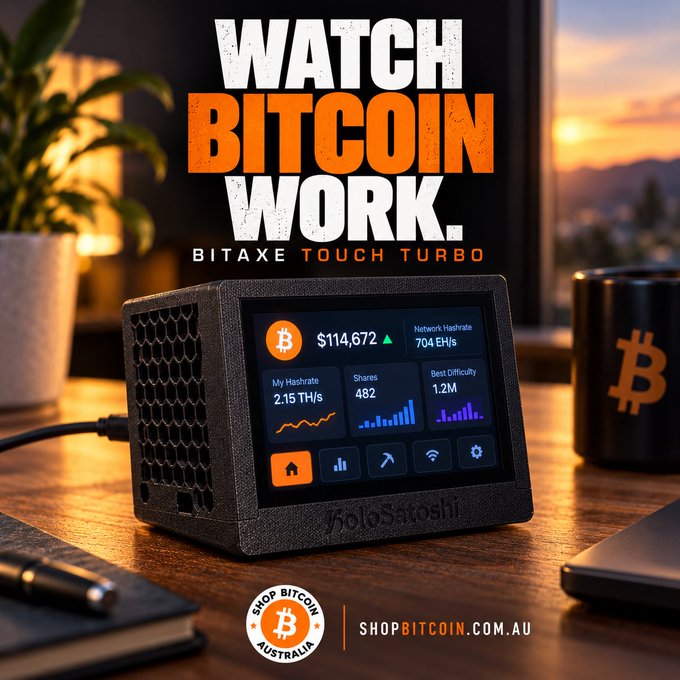 A promotional image showing a Bitaxe Touch Turbo Bitcoin mining device on a desk, displaying metrics like 'Bitcoin $114,672', 'Network Hashrate 704 EH/s', and 'My Hashrate 2.15 TH/s'. The text 'WATCH BITCOIN WORK' appears at the top, and 'SHOPBITCOIN.COM.AU' is at the bottom.
