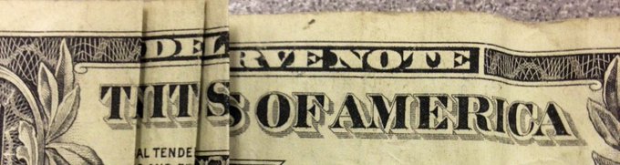 A close-up view of the back of a US one-dollar bill showing the words 'THIS OF AMERICA' in detailed engraving.
