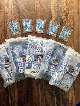 A wooden surface displaying multiple sachets and cards of a product labeled "RISING SUN" with what appears to be coffee or a similar beverage.