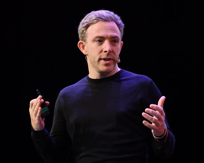 A man with light brown hair, wearing a black sweater and a headset microphone, gestures while speaking on stage against a dark background. The image accompanies a post highlighting @dominic_w's statement about Internet Computer cloud engines expanding to hyperscaler infrastructure like AWS, referencing the $ICP ticker.