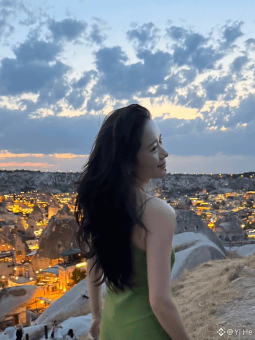 A woman with long dark hair stands overlooking a scenic valley at dusk, captioned with the handle "Yi He (@YiHe)" and praised in the post as the inspiring figure behind Binance, whose advocacy for digital currency motivated the author to invest heavily in cryptocurrency.