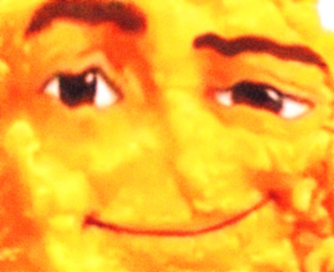 A stylized, illustrated face rendered in warm yellow and orange tones with a smirking expression.