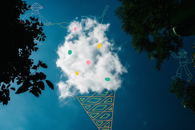 A whimsical illustration of a fluffy cloud shaped like an ice cream scoop with colorful sprinkles resting in a patterned yellow and teal cone, set against a blue sky with doodle-style characters and trees in the background.