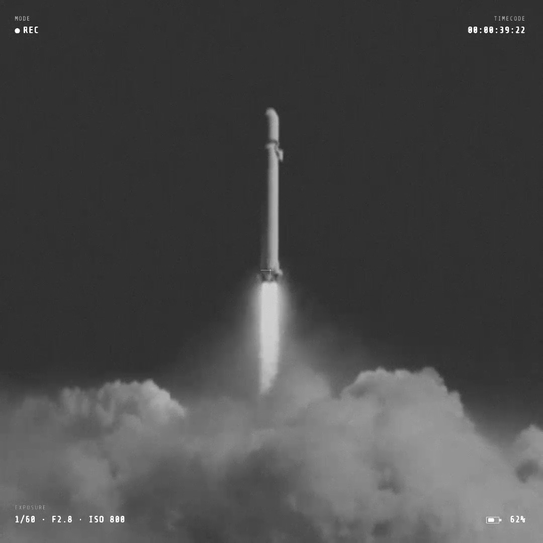 A black and white photo of a rocket launching through clouds, styled with camera overlays showing REC mode, timecode 00:00:39:22, and exposure settings 1/50 F2.8 ISO 800.