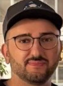 A man wearing glasses and a baseball cap with "CHAMP" written on it smiles at the camera. The image appears to be a selfie of the person posting, with the "CHAMP" cap serving as a visual joke playing on the caption's "99% sure" statement, humorously suggesting certainty while the post itself remains speculative.