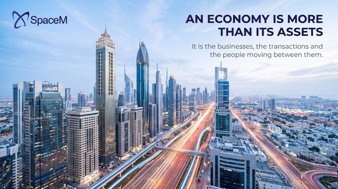 SpaceM promotional image showing a modern city skyline with skyscrapers and highways, featuring the tagline 'AN ECONOMY IS MORE THAN ITS ASSETS — It is the businesses, the transactions and the people moving between them.'