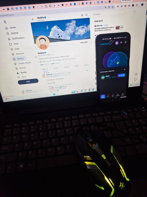 A laptop displaying the X profile of 'Nohita' alongside a glowing Razer gaming mouse.
