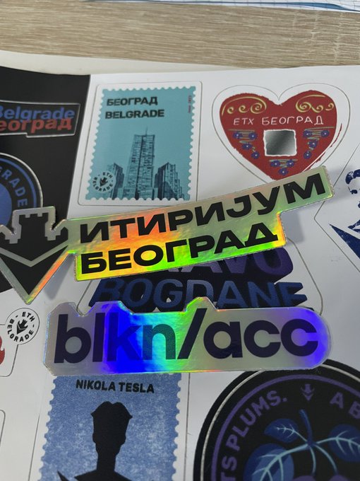 A collection of stickers features Belgrade-themed designs including stamps labeled 'БЕОГРАД/BELGRADE', a heart magnet with 'ЕТХ БЕОГРАД', and a holographic sticker reading 'ИТИРИЈУМ БЕОГРАД'.