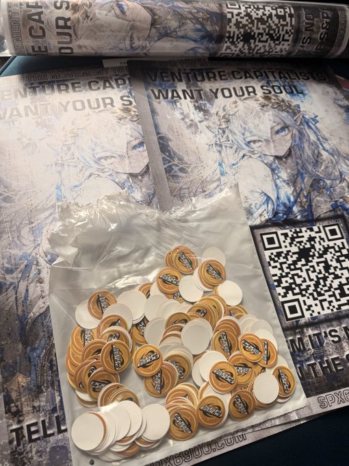 A clear plastic bag filled with branded "SPX6900" poker-style chips sits atop promotional posters reading "VENTURE CAPITALISTS WANT YOUR SOUL," with a QR code visible alongside, tying in to the caption "London knows what's coming SPX6900" as part of the meme coin's marketing campaign.