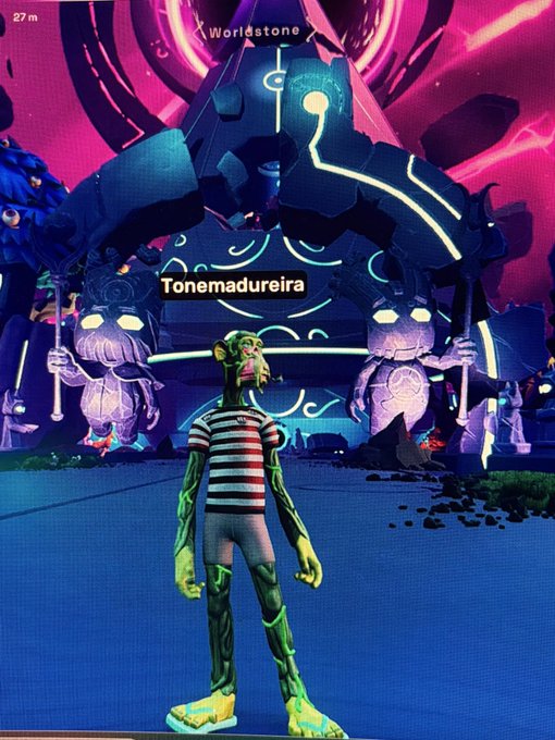 The image features a cartoon character, possibly a monkey or a human, standing in front of an archway with two other cartoon characters behind him. The character has a striped shirt and green pants, giving off a playful vibe. The background includes a purple sky and neon lights, creating a vibrant atmosphere. The post that accompanies the image reads: "GM happy Thursday made it to @OthersideMeta".