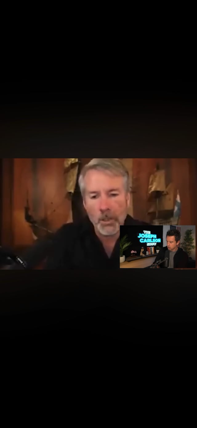 A video call screenshot showing a man with gray hair on the main screen, with a smaller inset video in the corner showing a man in a studio with a neon sign reading 'THE JOSEPH CARLEON SHOW'.