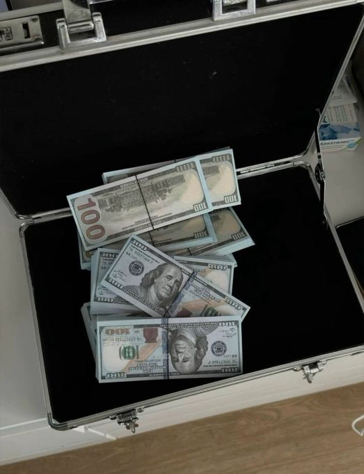 An open briefcase filled with stacks of $100 bills is displayed alongside a partial box of additional cash, visually reinforcing the post's promise of "making a lot of money."