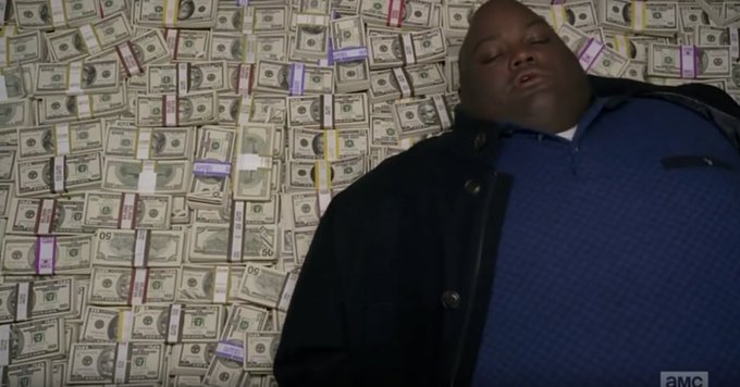 A man in a blue checkered shirt and dark jacket stands against a wall covered in hundred-dollar bills, with the AMC logo visible in the corner. The scene reflects a gambling or money-themed post, likely from Roobet's promotional content featuring Joshua Van.