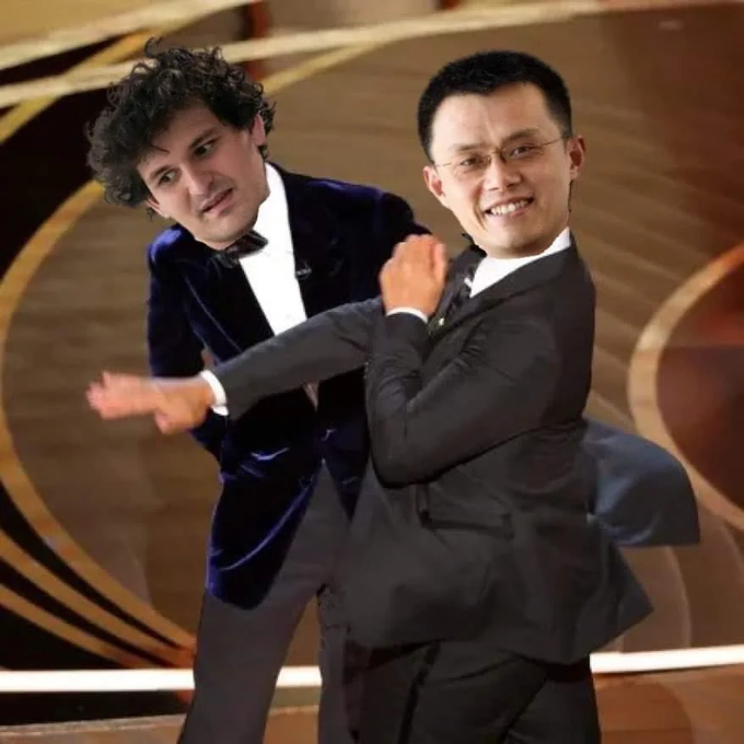 A photo showing two men in suits appearing to playfully wrestle or dance together on a stage with a golden background.