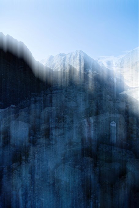 An abstract, moody image features a snow-capped mountain peak visible through a textured, streaky blue and black foreground.