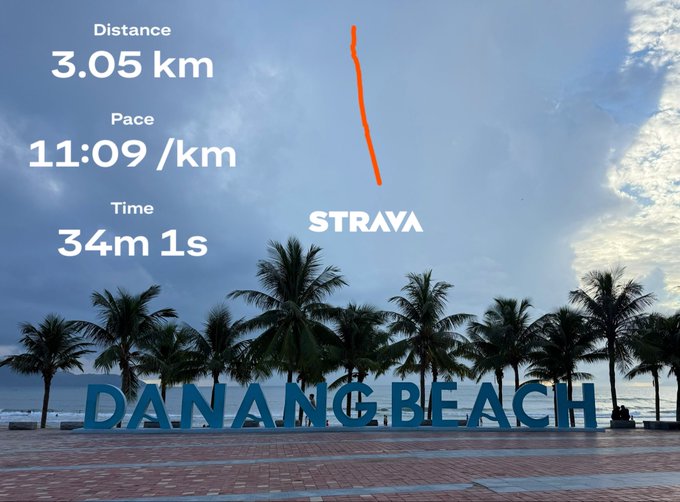 A Strava workout summary showing a distance of 3.05 km, pace of 11:09 /km, and time of 34m 1s, overlaid on a photo of the 'DANANG BEACH' sign lined with palm trees.